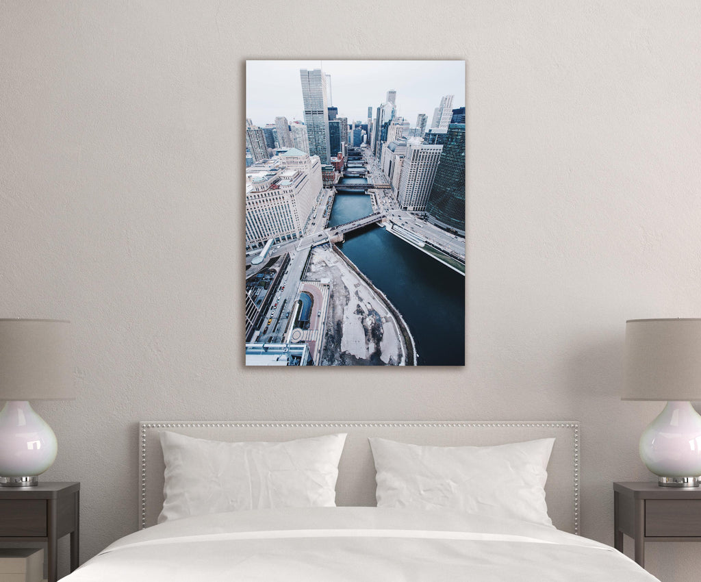 Snowy City River Aerial View Glass Wall Art in a living room interior