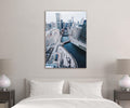 Snowy City River Aerial View Glass Wall Art in a living room interior