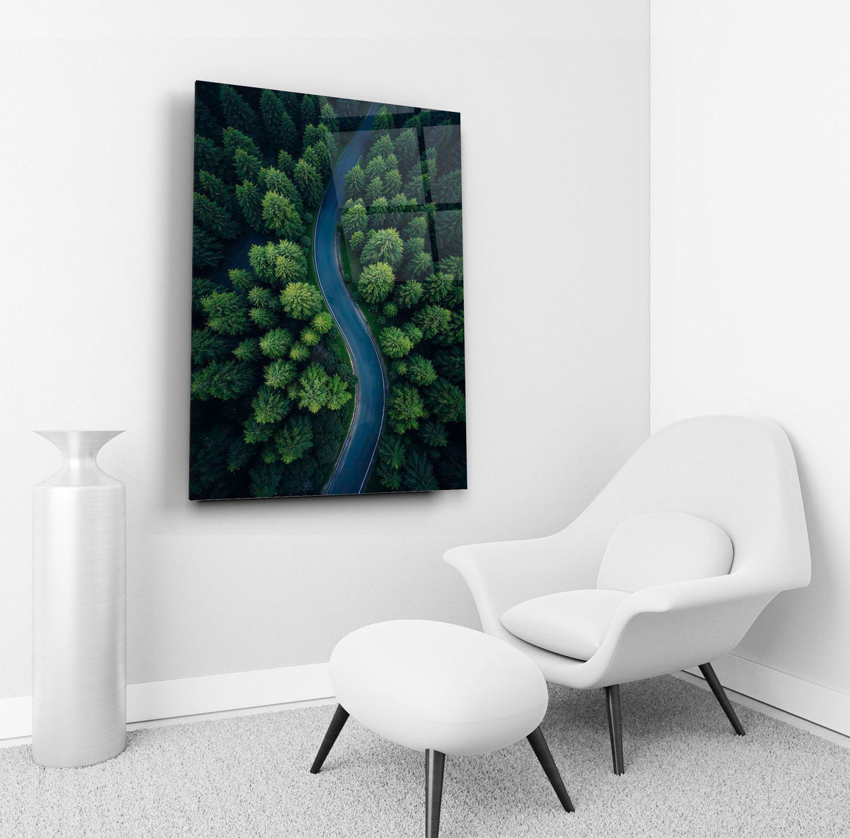 Winding Road Through Green Forest Glass Wall Art in a living room interior