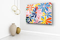 Colorful Abstract Daisies Glass Wall Art in a living room interior