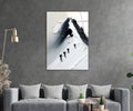 Climbers on a Snowy Mountain Peak Glass Wall Art in a living room interior