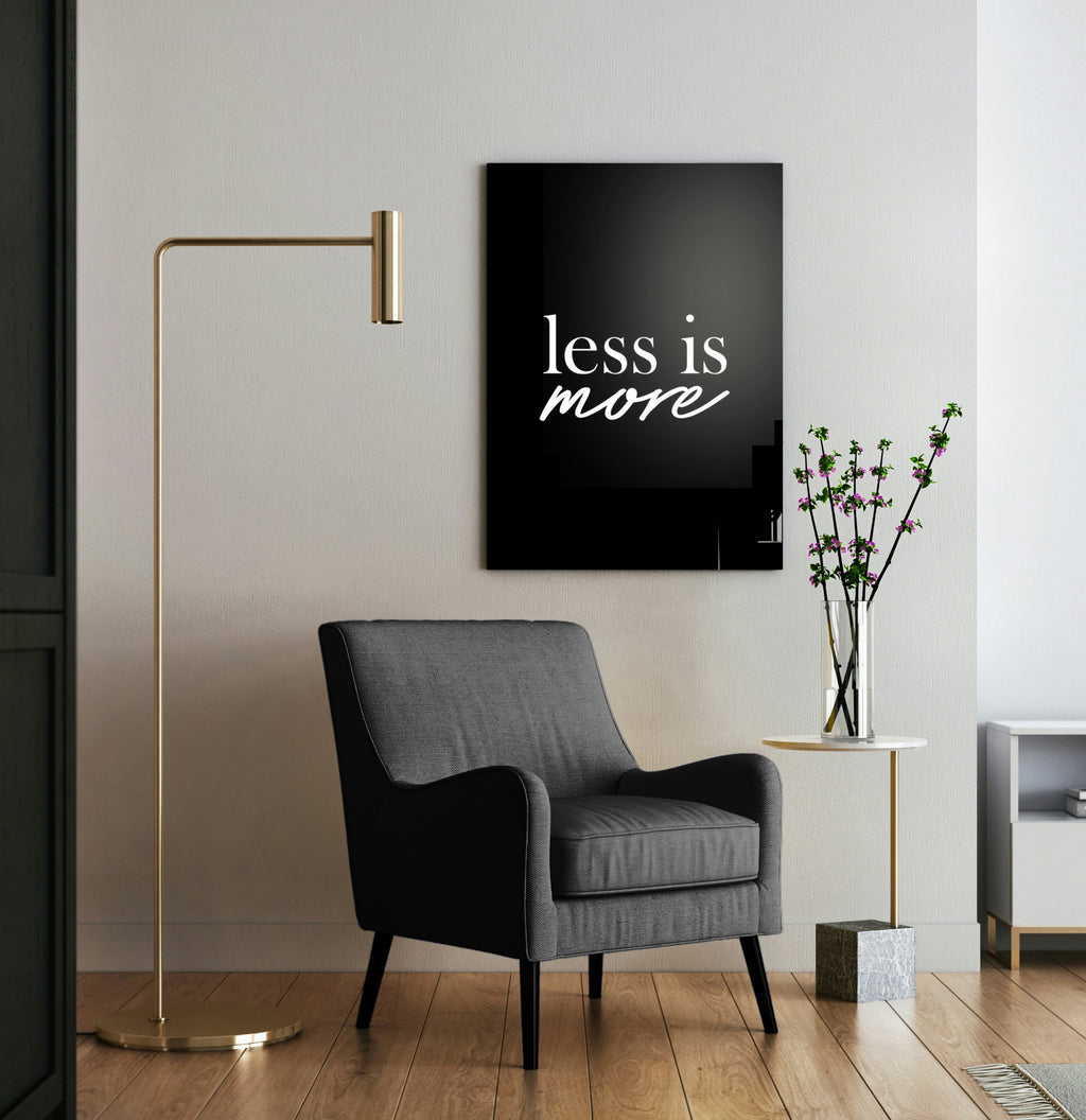 Less Is More Minimalist Quote Glass Wall Art in a living room interior